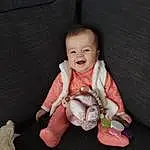 Visage, Joue, Peau, Sourire, Head, Yeux, Couch, Comfort, Human Body, Baby & Toddler Clothing, Textile, Sleeve, Dress, Gesture, Baby, Finger, Lap, Bambin, Happy, Thumb, Personne