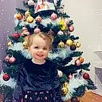 Christmas Tree, Head, Sourire, Christmas Ornament, Photograph, Facial Expression, Blanc, Human Body, Holiday Ornament, Debout, Happy, Christmas Decoration, Bambin, Evergreen, Ornament, Woody Plant, People, Baby & Toddler Clothing, Beauty, Christmas Eve, Personne, Joy