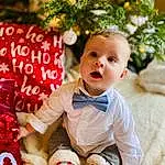 Facial Expression, Baby & Toddler Clothing, Sleeve, Happy, Baby, Bambin, People, Enfant, Beauty, Herbe, Sock, Event, Pattern, Noël, Arbre, Assis, Christmas Decoration, Holiday, Fun, Carmine, Personne, Surprise