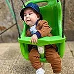 Visage, Vêtements d’extérieur, Yeux, Green, Sleeve, Baby & Toddler Clothing, Baby, Herbe, Public Space, Bambin, Leisure, Sneakers, Recreation, Fun, Swing, Happy, People In Nature, Assis, City, Comfort, Personne, Headwear