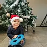 Sourire, Christmas Tree, Facial Expression, Christmas Ornament, Vehicle, Debout, Baby & Toddler Clothing, Tire, Holiday Ornament, Woody Plant, Christmas Decoration, Bambin, Ornament, Happy, Arbre, Fun, Holiday, Event, Wheel, Hiver, Personne, Joy, Headwear