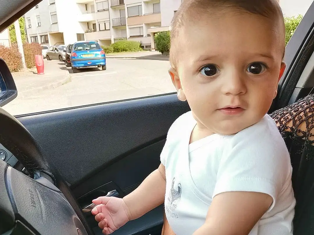 Hand, Car, Fenêtre, Vehicle, Building, Vrouumm, Automotive Design, Vehicle Door, Automotive Exterior, Steering Wheel, Automotive Mirror, Baby & Toddler Clothing, Auto Part, Baby, Bambin, Car Seat Cover, Personal Luxury Car, Car Seat, Windshield, Head Restraint, Personne