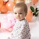 Head, Facial Expression, Dress, Textile, Baby & Toddler Clothing, Sleeve, Happy, Rose, One-piece Garment, Baby, Balloon, Bambin, Petal, Enfant, Event, Formal Wear, Day Dress, Peach, Personne