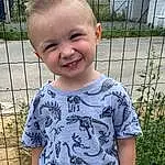 Clothing, Chin, Coiffure, Plante, Sourire, Facial Expression, Human Body, Baby & Toddler Clothing, Neck, Sleeve, Debout, T-shirt, Herbe, Cool, Bambin, Fence, Summer, Pattern, Happy, Baby, Personne, Joy