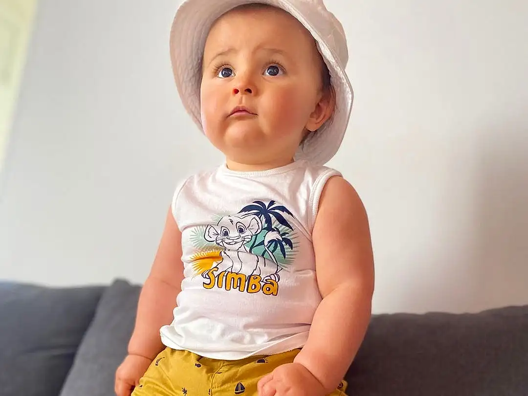 Joue, Peau, Stomach, Baby & Toddler Clothing, Neck, Sleeve, Waist, Thigh, T-shirt, Knee, Happy, Bambin, Baby, Trunk, Enfant, Human Leg, Elbow, Shorts, Chest, Assis, Personne, Surprise