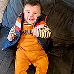 Visage, Brown, Footwear, Head, Sourire, Shoe, Yeux, Sleeve, Orange, Comfort, Sneakers, Baby & Toddler Clothing, Happy, Bambin, Bois, Thumb, Fun, Couch, Assis, Personne, Joy