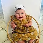 Joue, Sourire, Peau, Yeux, Dress, Baby & Toddler Clothing, Chair, Sleeve, Baby, Happy, Rose, Bambin, Fun, Enfant, Human Leg, Fashion Accessory, Event, Magenta, Assis, Fashion Design, Personne, Joy, Headwear