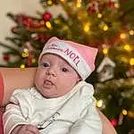 Visage, Christmas Tree, Facial Expression, Christmas Ornament, Human Body, Sleeve, Happy, Baby, Headgear, Christmas Decoration, Baby & Toddler Clothing, Bambin, Ornament, Beauty, Event, Cap, Holiday, NoÃ«l, Enfant, Holiday Ornament, Personne, Headwear