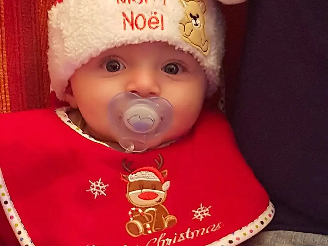 Joue, Head, Peau, Lip, Santa Claus, Baby & Toddler Clothing, Sleeve, Baby, Cap, Headgear, Rose, Red, Happy, Bambin, Costume Hat, Knit Cap, NoÃ«l, Event, Holiday, Tradition, Personne, Headwear