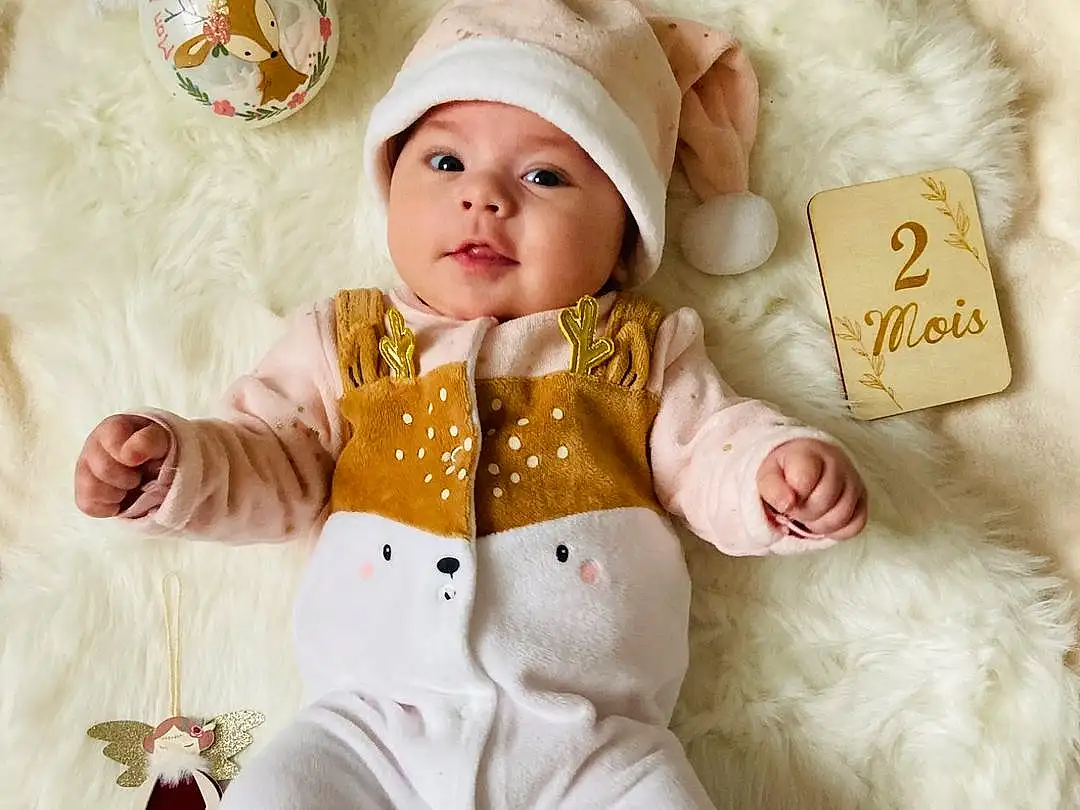 Clothing, Visage, Blanc, Baby & Toddler Clothing, Textile, Sleeve, Baby, Headgear, Collar, Rose, Happy, Doll, Bow Tie, Baby Sleeping, Bambin, Linens, Comfort, Pattern, Enfant, Poil, Personne, Headwear