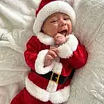 Visage, Blanc, Sourire, Human Body, Comfort, Santa Claus, Baby & Toddler Clothing, Textile, Sleeve, Baby, Chapi Chapo, Fur Clothing, Red, Bambin, Jacket, Happy, Event, Holiday, NoÃ«l, Lap, Personne, Headwear