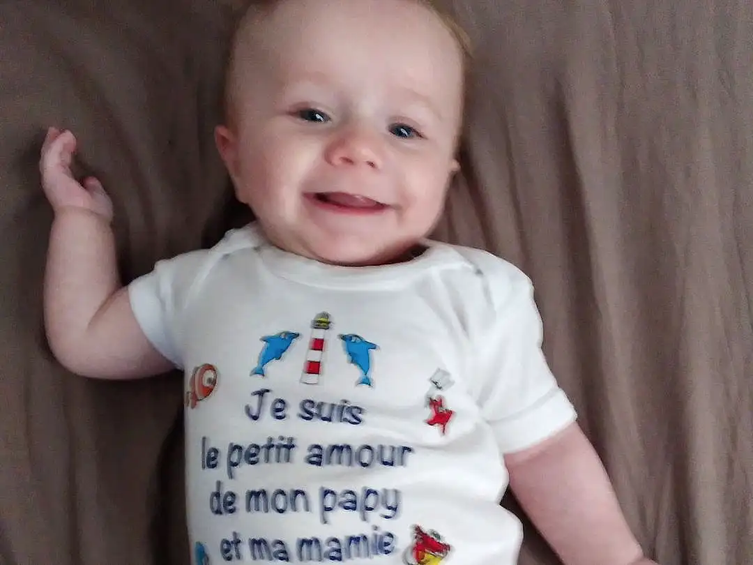 Visage, Joue, Peau, Sourire, Chin, Facial Expression, Blanc, Baby & Toddler Clothing, Neck, Sleeve, Textile, Debout, Happy, Gesture, Baby, Finger, Bambin, T-shirt, Comfort, Personne, Joy