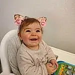 Joue, Sourire, Bras, Sleeve, Baby & Toddler Clothing, Happy, Chair, Bambin, Baby, Enfant, Baby Playing With Toys, Headpiece, Headband, Room, Fashion Accessory, Fun, Comfort, Assis, Jewellery, Laugh, Personne, Joy